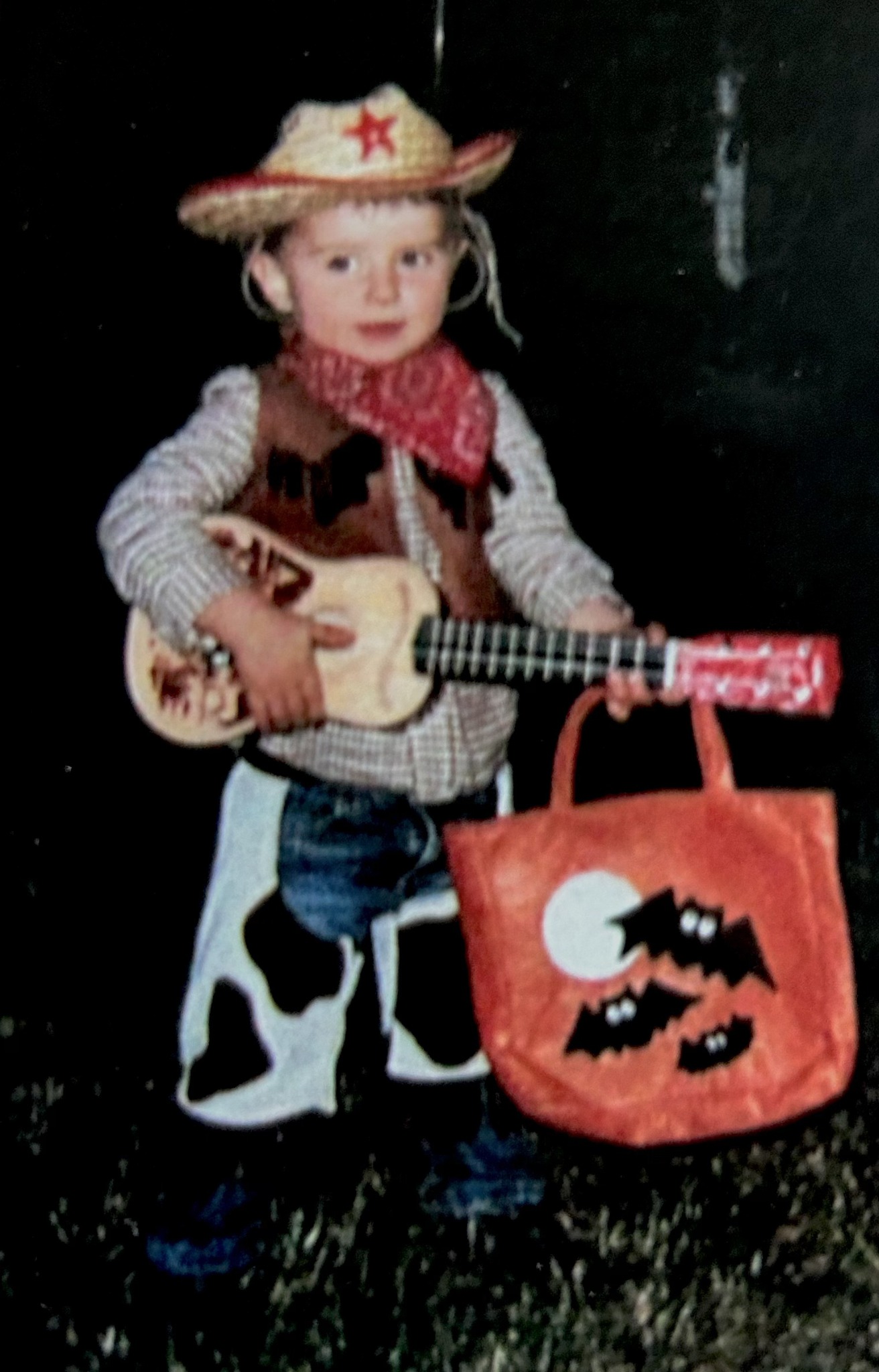 Young Torben Mucchetti dressed like a cowboy holding a toy guitar